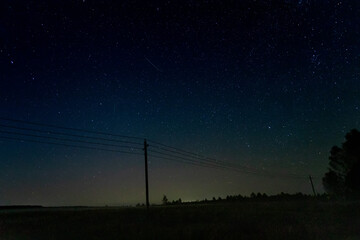 Silhouettes of pillars against the background of the starry sky with meteors