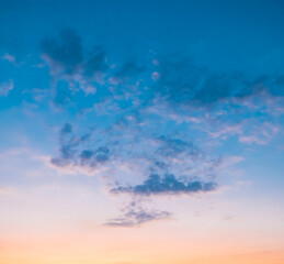 Sundown cloudscape. Fluffy clouds in the sunset of dark blue - pink - orange sky. Dreamy evening. Beautiful daybreak