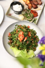 A fresh and vibrant Lebanese tabbouleh salad made with finely chopped parsley, tomatoes, mint, and a citrusy dressing, served with crisp lettuce leaves for a refreshing and healthy Middle Eastern dish