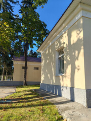 Fototapeta premium historic building with red brick columns and a sloping roof, nestled under large trees. The structure highlights the blend of classical architecture and natural surroundings, common in preserved