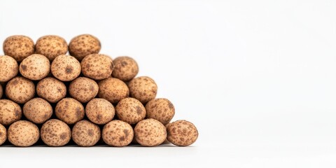 A minimalist composition of stacked brown round snacks on a white background.