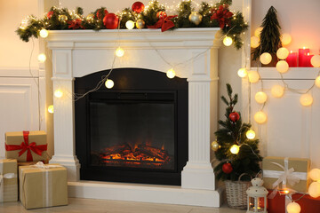 Stylish fireplace with Christmas decor and presents in cozy room