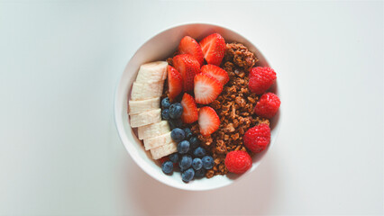 Overhead View Of Healthy Breakfast In Bowl With Granola And Fresh Fruit On White Background