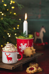 Gorąca czekolada z bitą śmietaną w świątecznym kubku. © Dorota