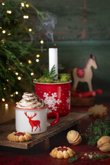 Gorąca czekolada z bitą śmietaną w świątecznym kubku. © Dorota