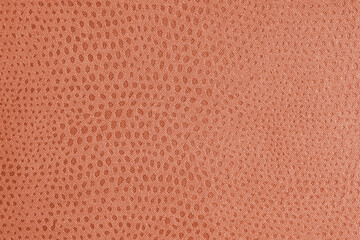 Cloth structure of jacquard orange fabric with abstract shabby spotted embossed texture closeup, macro. Upholstery, decorative cloth structure, home decor canvas. Background, backdrop, wallpaper.