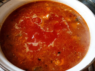 A pot filled with soup sitting on top of a stove