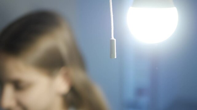 Turn On the Light in a Dark Room, Woman Turning the Light On a Led Bulb, Girl Turns the Light On at Home, Pull Switch On Off