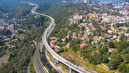 The Insurgente train that connects Mexico City and Toluca runs along a winding stretch of Sante Fe in its residential area. In this part the elevated train tracks run above the highway.