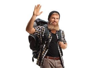 Bearded guy hiker with a backpack waving at the camera