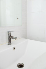 The stained faucet on the white ceramic sink basin.