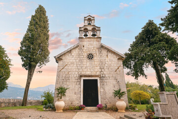Picturesque stone church with bell tower at sunset in Montenegro