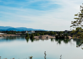 A calm lake with a few buildings in the background