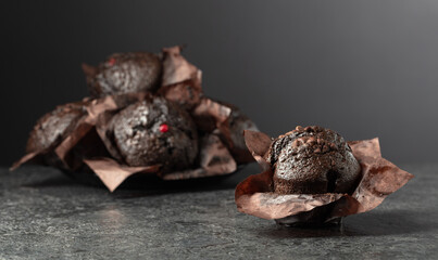 Dark chocolate muffins on a black table.