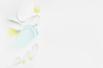 A variety of cosmetic product textures with cream, gel, and drops displayed on a light surface with room for text