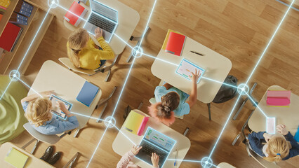 Top down View: Children in a School Use Tablets and Laptops to Study Digital Literacy, AI Data Lines Connect into Learning. Diverse Kids Connected Through Digital Knowledge Network, Modern Technology