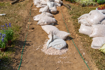 stacks of white sandbags full of garden gravel stone for paving in the recreation park
