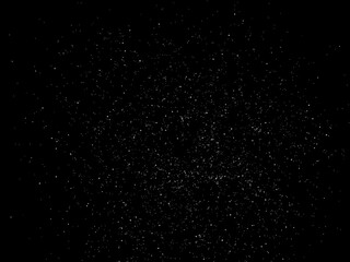 Tiny sawdust particles scattered across a dark black background, creating a sense of dynamic movement and energy, dust, night
