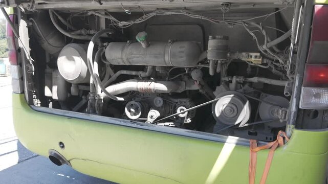 Close-up of a bus engine with exposed mechanical parts