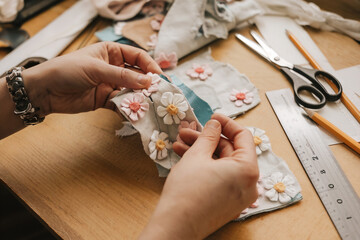 Manos haciendo manualidades con telas.  Generado con IA