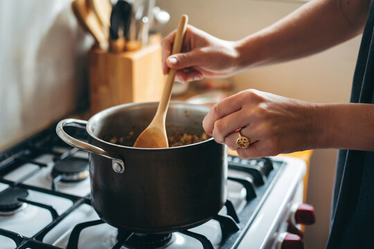 Manos preparando la comida en la coina de casa. Generado con IA