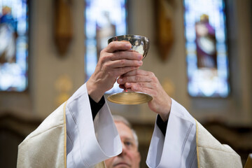  Manos de un sacerdote levantando el cáliz. Generado con IA