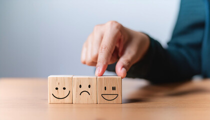 Customer service evaluation and satisfaction survey concepts. The client's hand picked the happy face smile face symbol on wooden blocks, copy space
