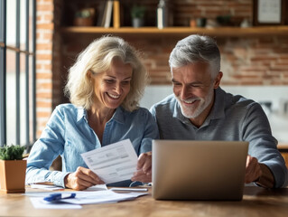 Fototapeta premium Joyful elder couple enjoying a moment of discovery while working together at home