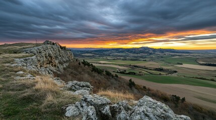 Dramatic Sunset Over Rocky Cliff And Farmland Valley