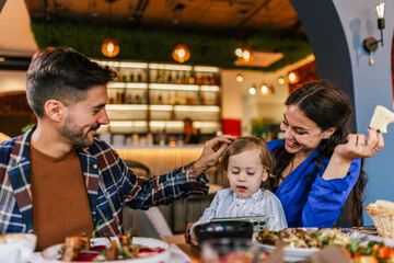Family of three eating in a restaurant delicious food. Food and drink concept.