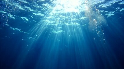 Fototapeta premium Sunbeams pierce through crystal-clear ocean waters, creating a mesmerizing underwater light show. Bubbles rise, dancing in the ethereal blue depths, inviting exploration and wonder.