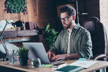Photo of smart clever programmer dressed shirt coding modern gadget indoors workstation workshop