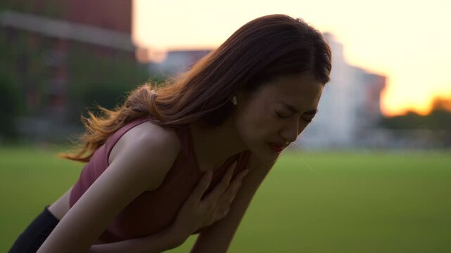 Young fitness woman feeling chest pain suffering after exercise outdoor in the city park, athlete girl after running in cardio injury with health problem condition, heart attack risk in female.