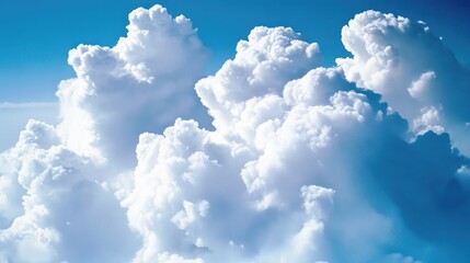 Fluffy white clouds billowing against a vibrant blue sky, creating a serene and picturesque atmosphere.