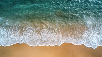 Dramatic Aerial View of Turquoise Waters Gently Lapping Against a Golden Sandy Beach Shoreline Under Bright Sunlight