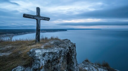 Weathered Driftwood Cross on a Rocky Cliff Overlooking a Serene Ocean Under a Moody Sky at Dusk