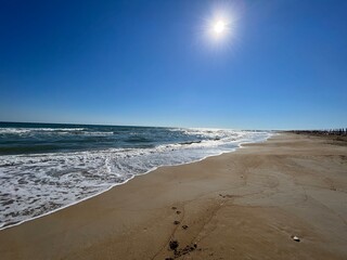 blue sky and beautiful tranquil sea at a lonely beach with golden sand with sun shining on the water