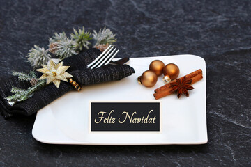 Feliz Navidad: Mesa con platos, cubiertos, adornos navideños y una tarjeta con la inscripción...