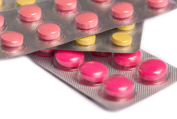 colored medical pills pink and yellow on white background