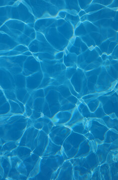background of azure pool water with light reflections without other people or objects