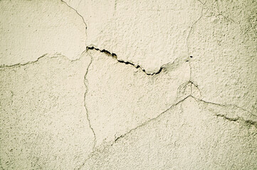 Antique stucco wall background, architectural background with curved cracks on the old stucco surface