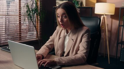 Shocked amazed Caucasian business woman worker businesswoman girl female working online laptop pc typing receive message good result great news wow shock positive promotion looking at camera at office