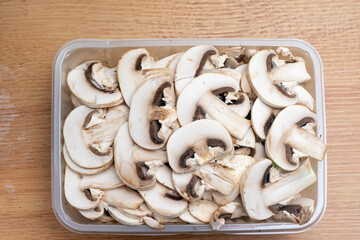 Fresh sliced white mushrooms on a kitchen countertop, ready for cooking, showcasing healthy ingredients and culinary preparation in a modern kitchen setting.