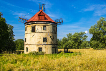 an old windmill in the middle of a beautiful landscape