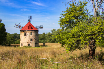 an old windmill in the middle of a beautiful landscape