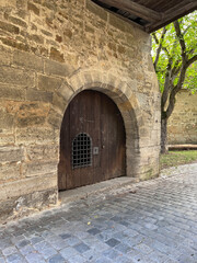 Fototapeta premium Door with grate in the wall of hospital bastion Spitalbastei, Rothenburg ob der Tauber, Bavaria, Middle Franconia, Germany