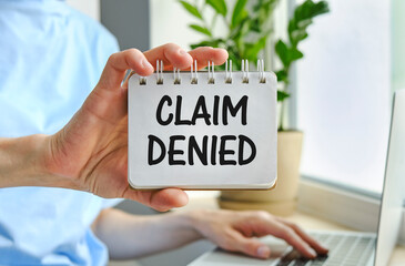 Business woman shows a card with text Claim Denied . Injury claim insurance concept