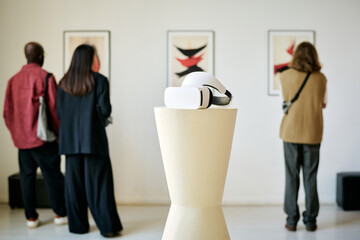 Group of people viewing contemporary artwork displayed on wall in modern art gallery, with focus on...
