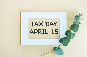 sentence tax day april 15 written with chalk on a blackboard, on a table with typewriter