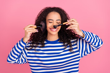 Fototapeta premium Portrait of nice young girl apply blush tone wear striped pullover isolated on pink color background